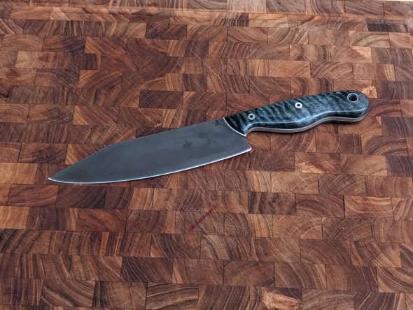 Custom chef knife shown from the opposite side on an end-grain board