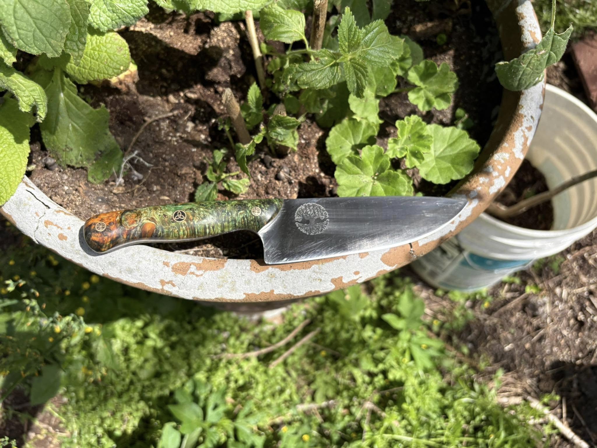 Finished custom knife with green handle photographed outdoors