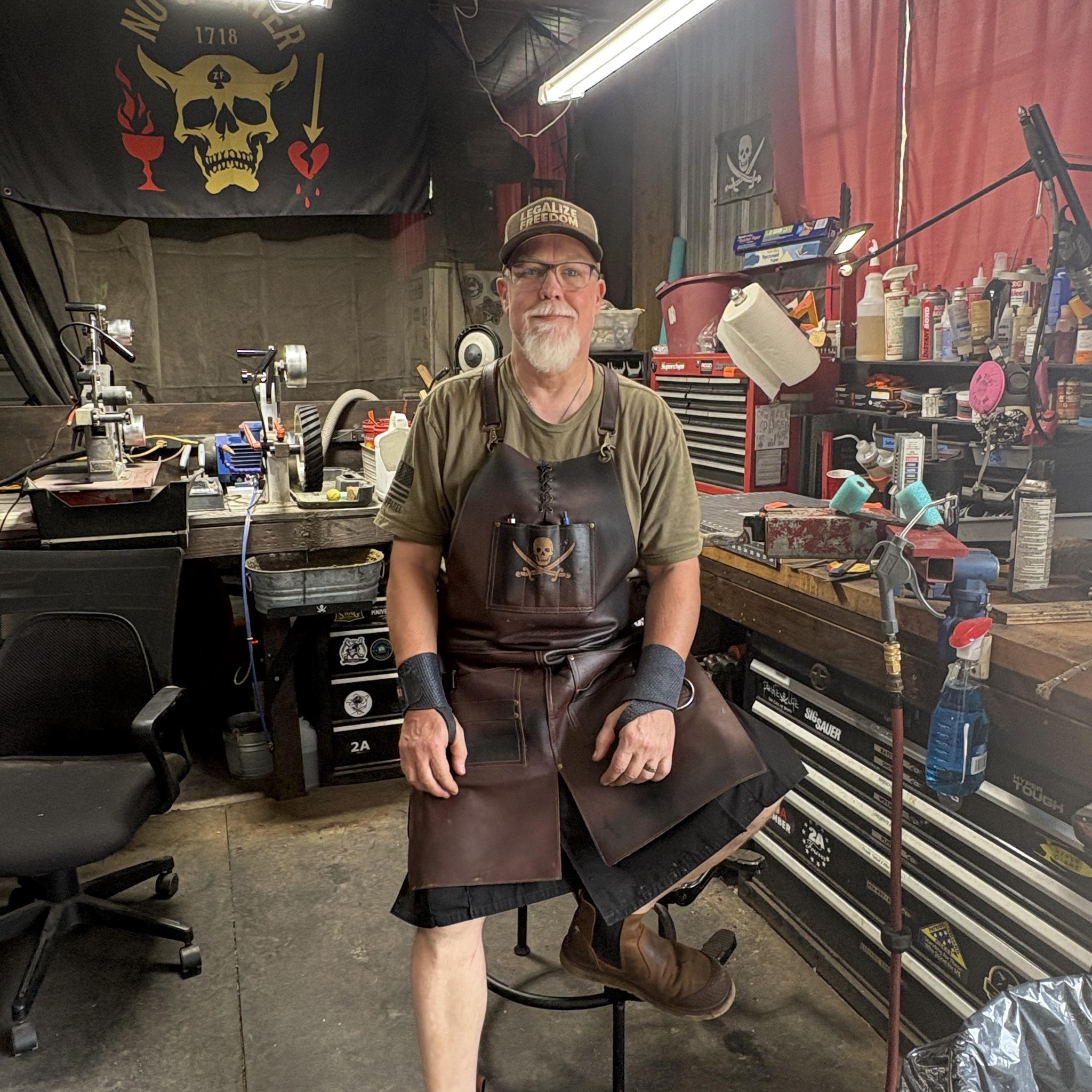 No Quarter Knives maker seated in the workshop